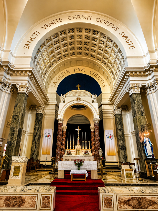 Interior of the Church of Saints Peter and Paul in Athlone, Ireland, featuring the ornate high altar, marble columns, arched ceiling and religious artwork.
