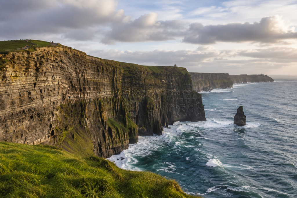 Panoramic view of the Cliffs of Moher in County Clare, Ireland, with rugged Atlantic cliffs, green headlands and waves along the coast.