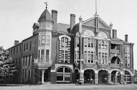 Historic black-and-white photo of the Turnell-Butler Hotel in Madison, Georgia. The building features ornate Victorian architecture with arched windows, a turret with a weather vane, and a richly detailed brick façade. This hotel once housed Oliver Hardy and his family in the 1890s.