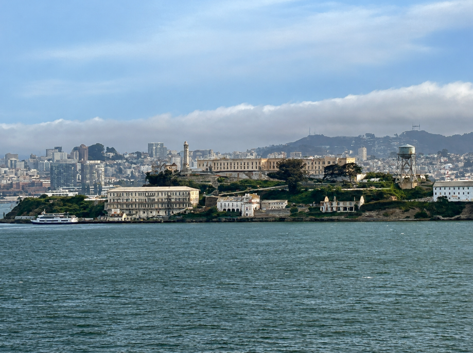 Alcatraz Island viewed from a cruise ship in San Francisco Bay in 2025, with the historic prison buildings, water tower and San Francisco skyline in the background.