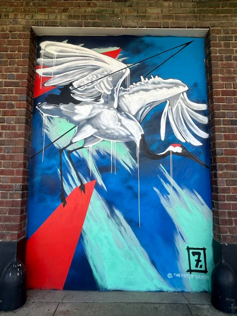 Three stylized white birds layered over blue, turquoise and red geometric shapes.