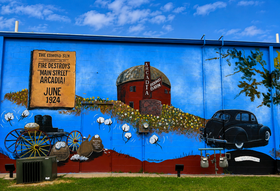 Windmill Shops mural panel depicting the Arcadia Round Barn, a 1924 Main Street fire headline, a wagon and a vintage car.