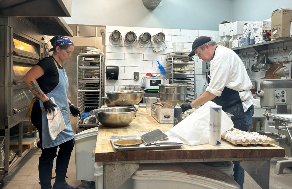 Bakers preparing fresh pastries inside the kitchen at The Patisserie on Main