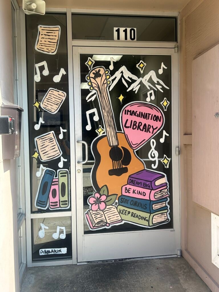 Painted Imagination Library window with guitar, books, music notes and Smoky Mountains in downtown Sevierville
