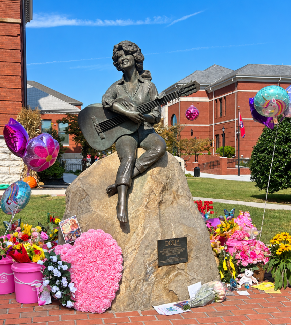Dolly Parton statue surrounded by flowers and tributes in downtown Sevierville, Tennessee