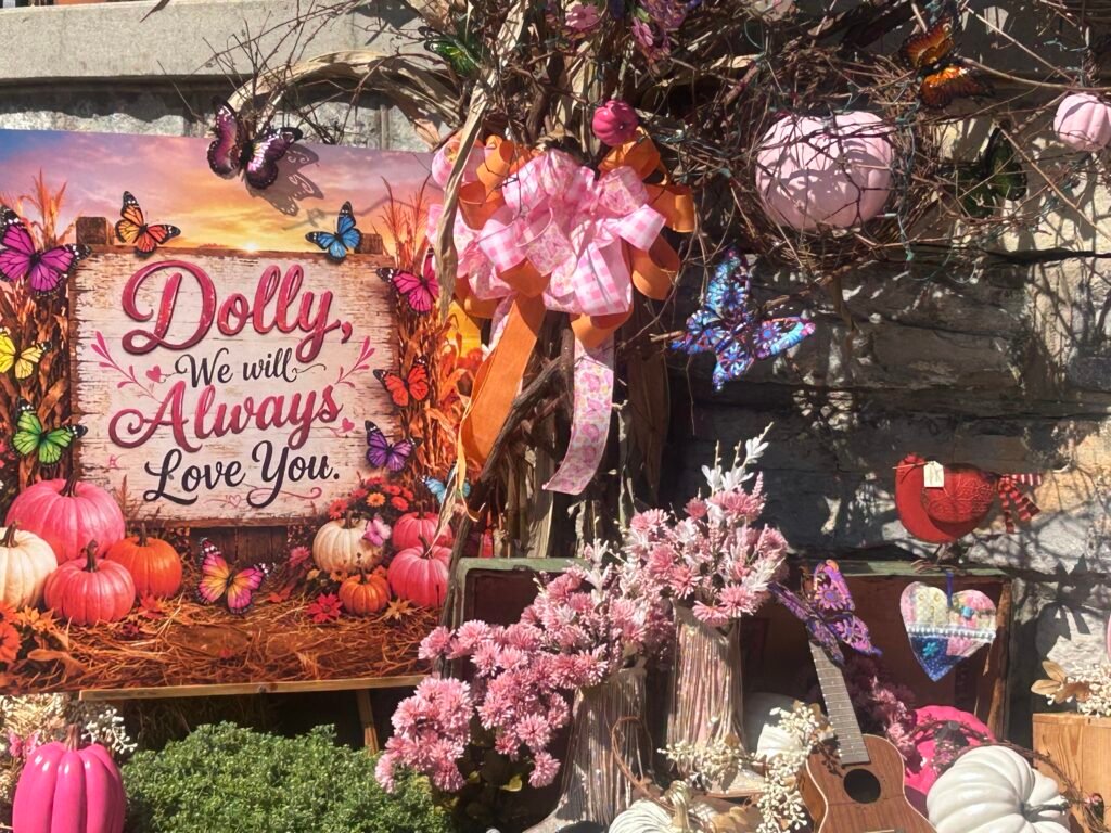 Dolly We Will Always Love You display with butterflies, pink flowers, pumpkins and a small guitar in Sevierville
