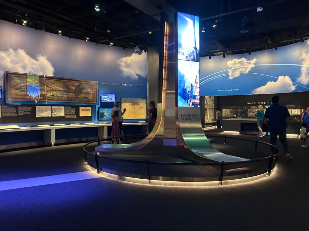 Visitors exploring exhibits about the design and construction of the Gateway Arch inside its underground museum
