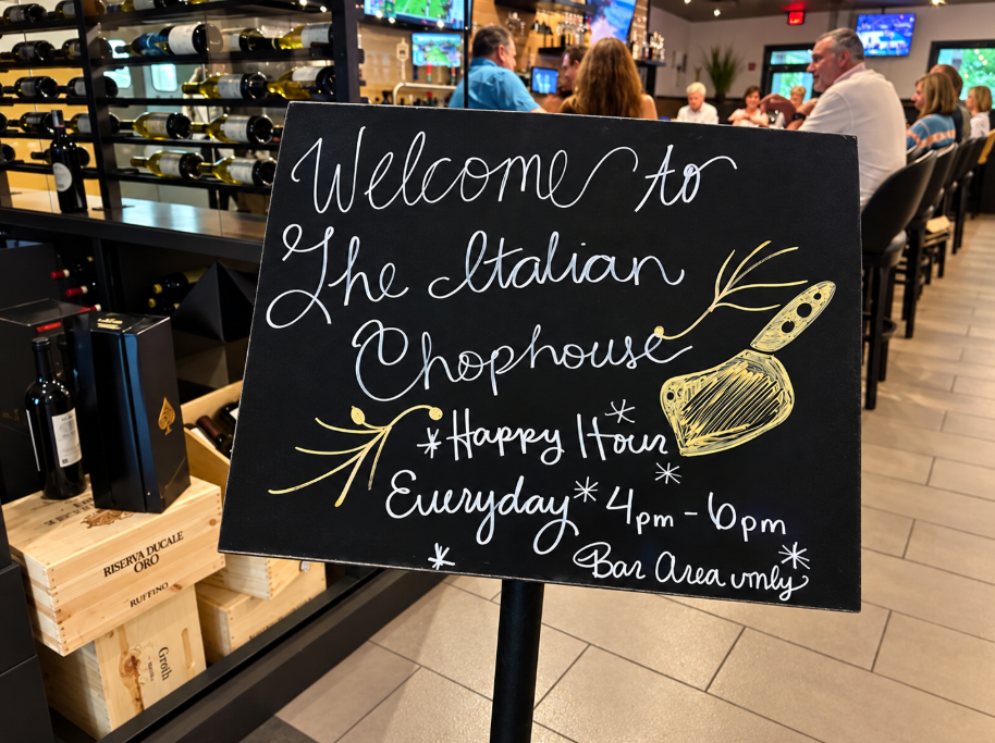 Happy Hour sign inside Italian Chophouse advertising daily Happy Hour from 4 to 6 p.m. in the bar area
