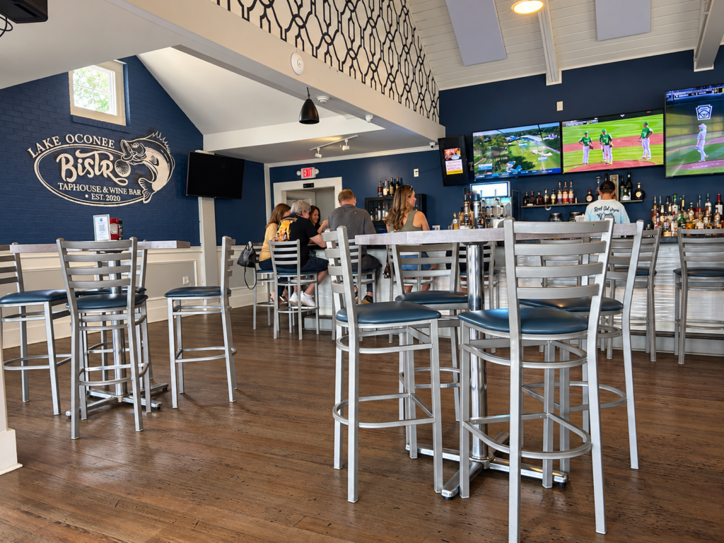 Bar and dining area inside Lake Oconee Bistro with high-top seating and lake-inspired blue décor