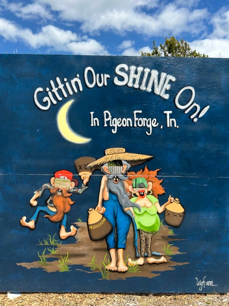 Cartoon moonshiners carrying jugs beneath a crescent moon in a Pigeon Forge mural.