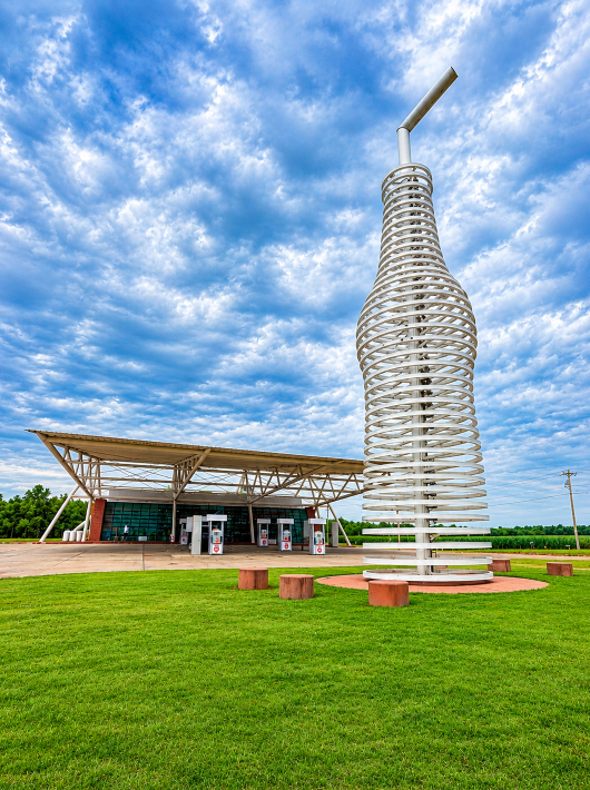 The 66-foot soda bottle sculpture and modern POPS 66 building beneath a dramatic sky in Arcadia, Oklahoma.