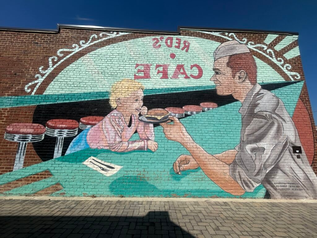 Red’s Café mural depicting a young blonde girl at the counter of the former Sevierville cafe associated with Dolly Parton