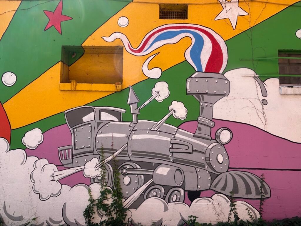 Gray steam locomotive painted on a colorful mural in St. Elmo, Chattanooga