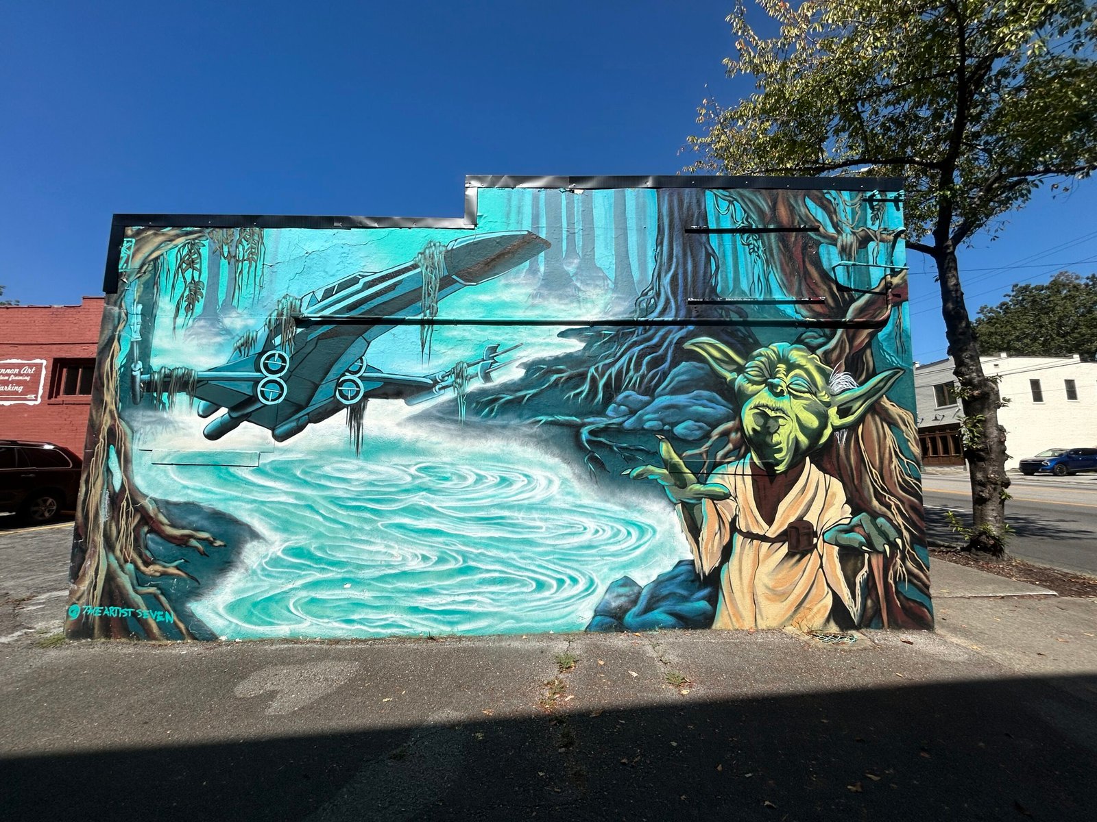 Star Wars street art mural with Yoda and an X-wing starfighter against a turquoise swamp landscape in Chattanooga, Tennessee