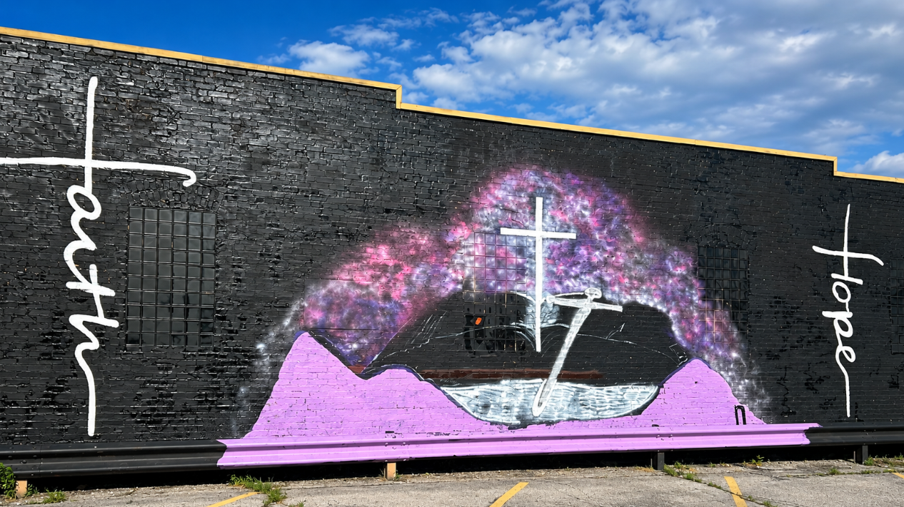 Faith and Hope mural painted on a black brick wall in Granite City, Illinois, with white lettering, crosses, and purple artwork