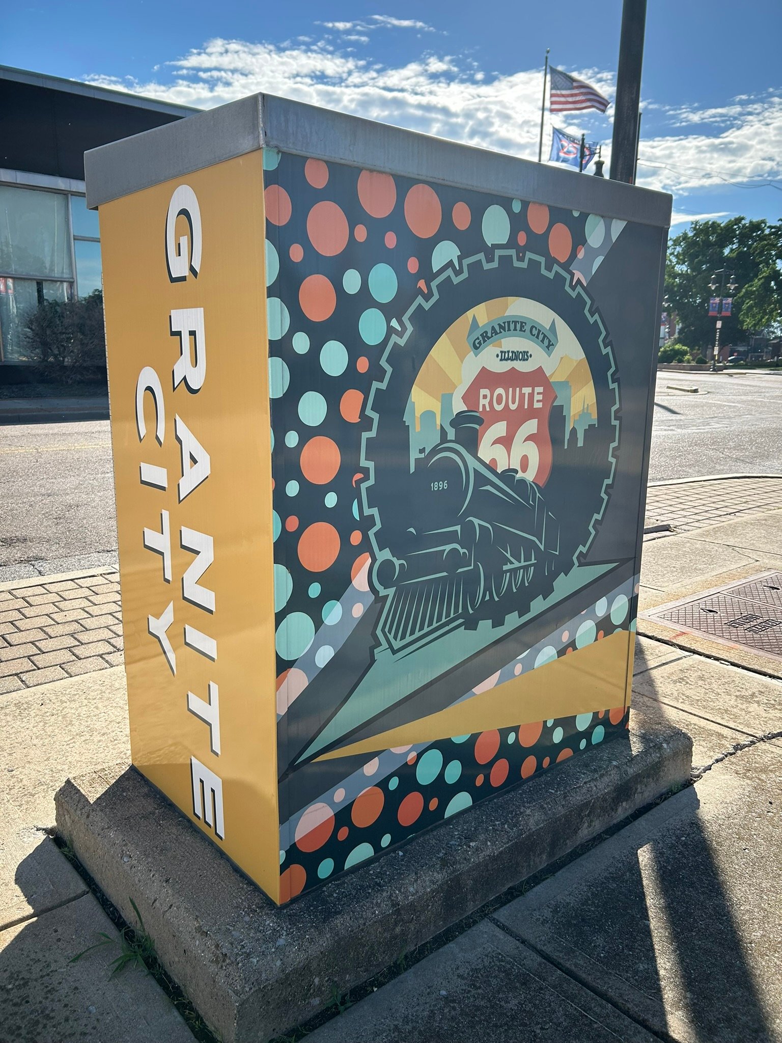 Decorated electrical box in Granite City featuring a Route 66 shield, steam locomotive illustration and vertical GRANITE CITY lettering.