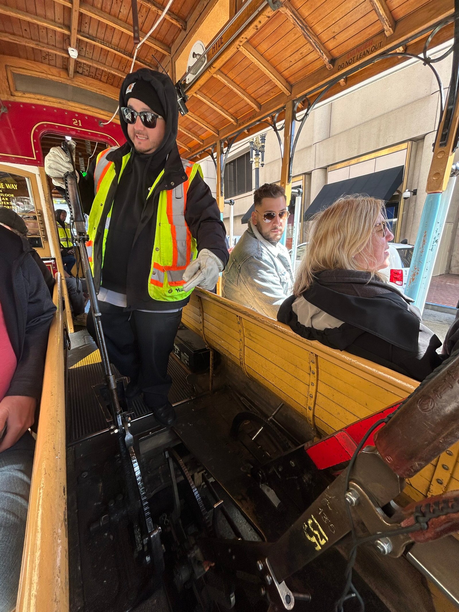 San Francisco cable car grip operator standing beside the mechanical controls inside a Powell line cable car