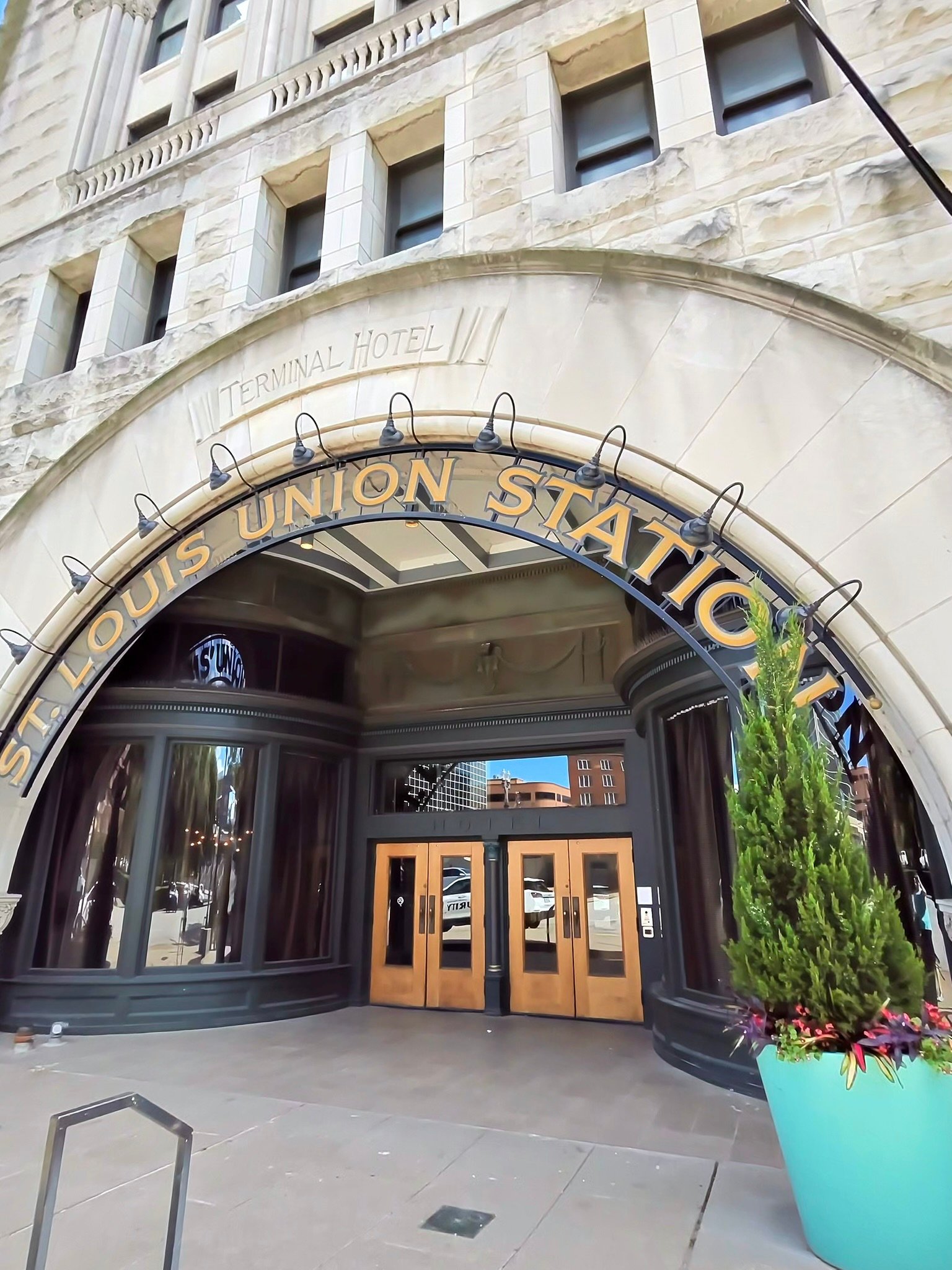Historic entrance to St Louis Union Station featuring an arched sign stone architecture and wooden doors